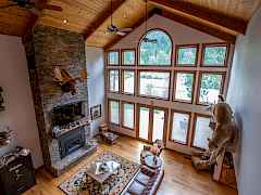 Massive wall of windows floods open living area with light and view of the river